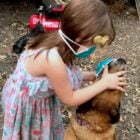 Bella puts a mask on Zander the dog - photo by reader Dolly Brown.