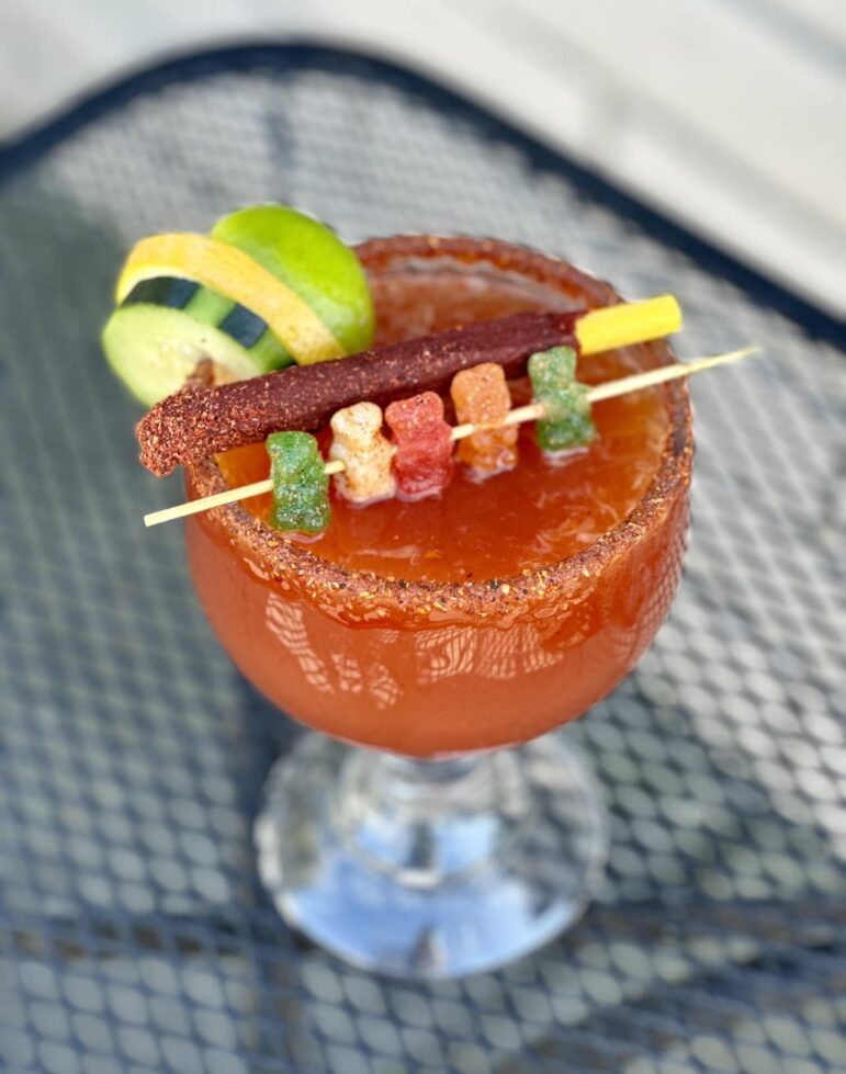 A photograph of a michelada in a goblet-like glass.