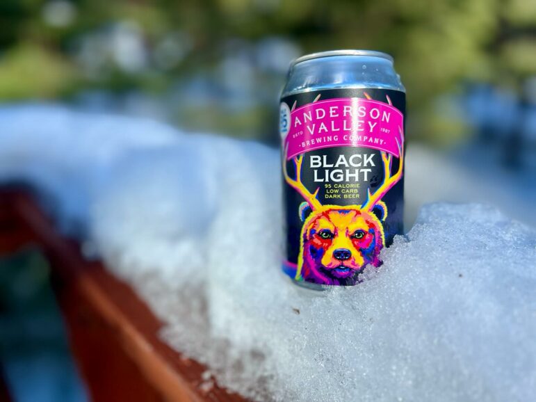 A photograph of a canned beer resting in snow.
